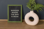 a vase with a plant in it next to a sign
