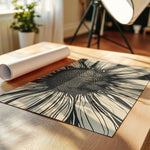 Black and beige bold sunflower pattern art print laying flat on a wooden table