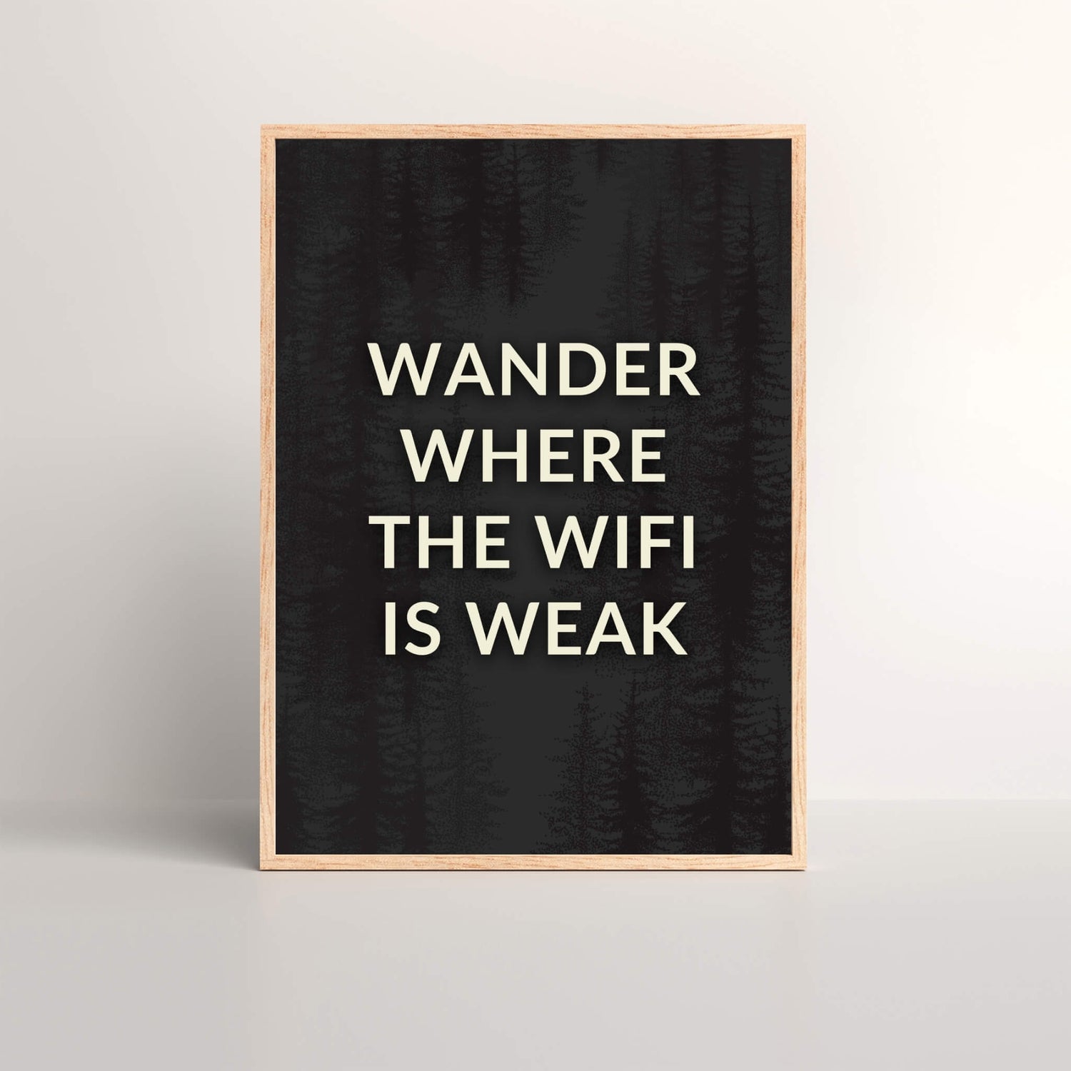 Wander Where The Wifi Is Weak Art Print with black background and white text in a oak picture frame sitting on a floor leaning against a wall