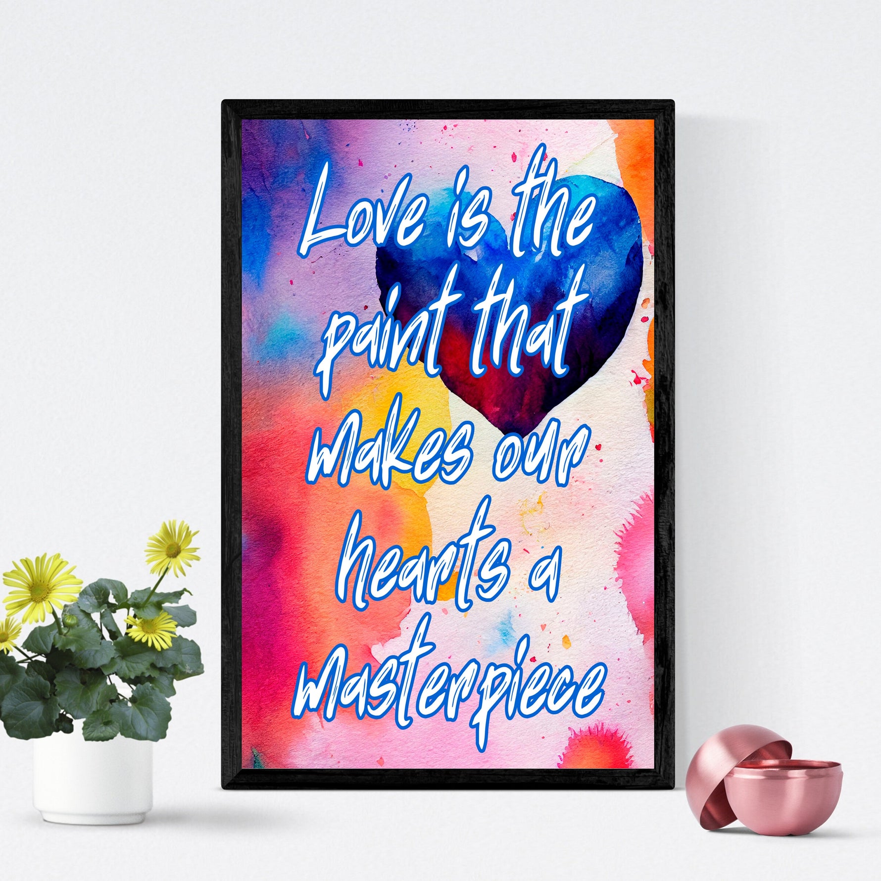 Fine Art Giclee Print - Love is the paint that makes our hearts a masterpiece -in a black picture frame leaning up against a white wall.