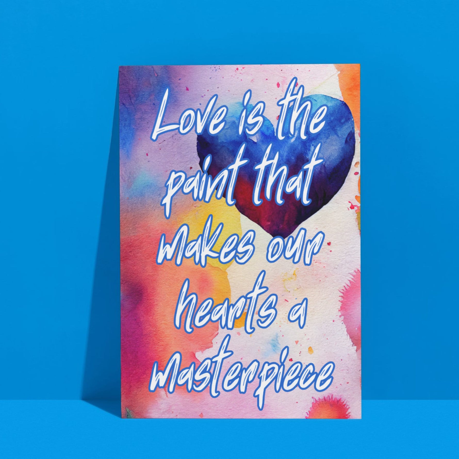 Fine Art Giclee Print - Love is the paint that makes our hearts a masterpiece - leaning up against a blue wall.