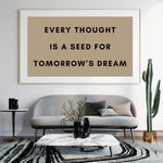 a picture of a brown and black quote on a white wall above a gray couch