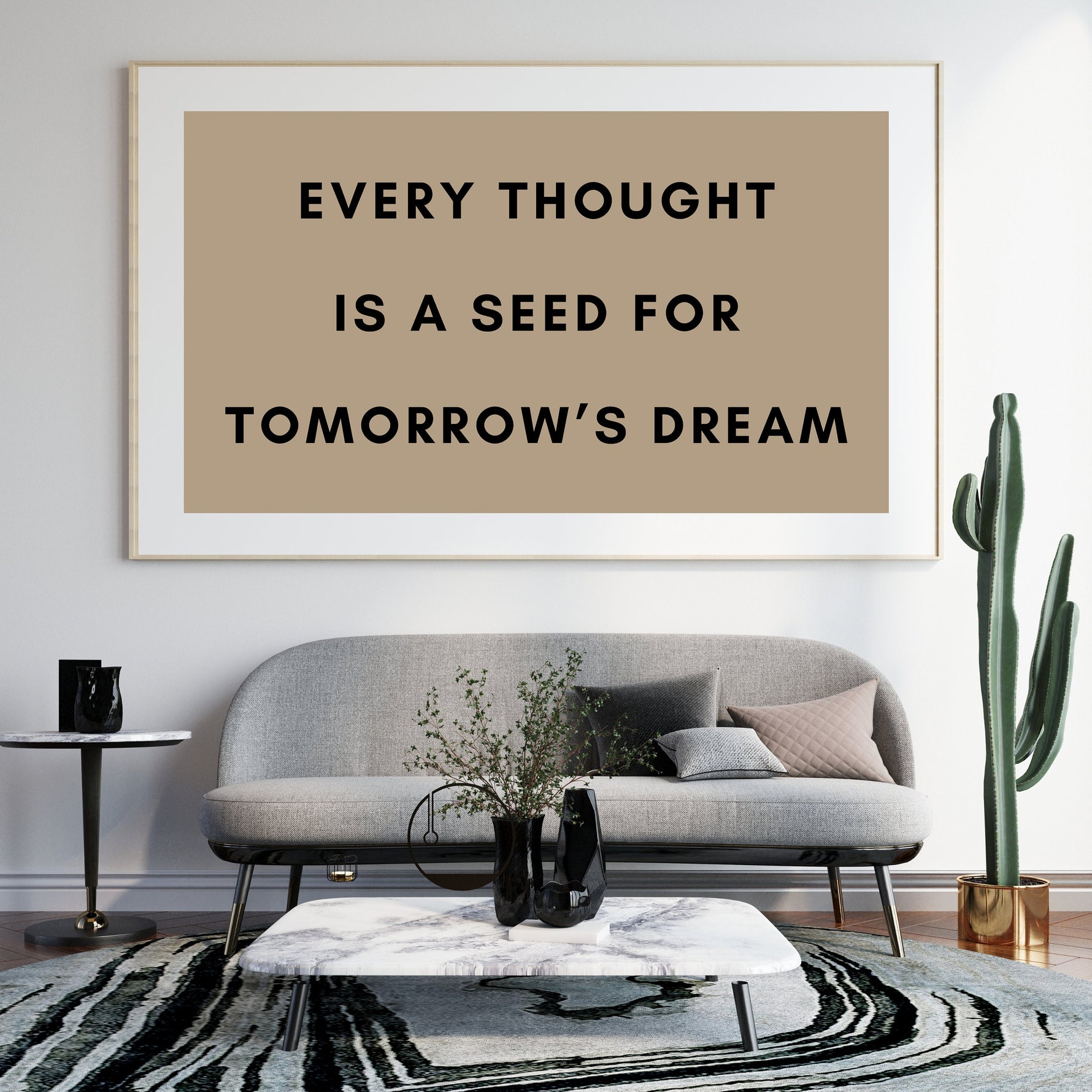 a picture of a brown and black quote on a white wall above a gray couch