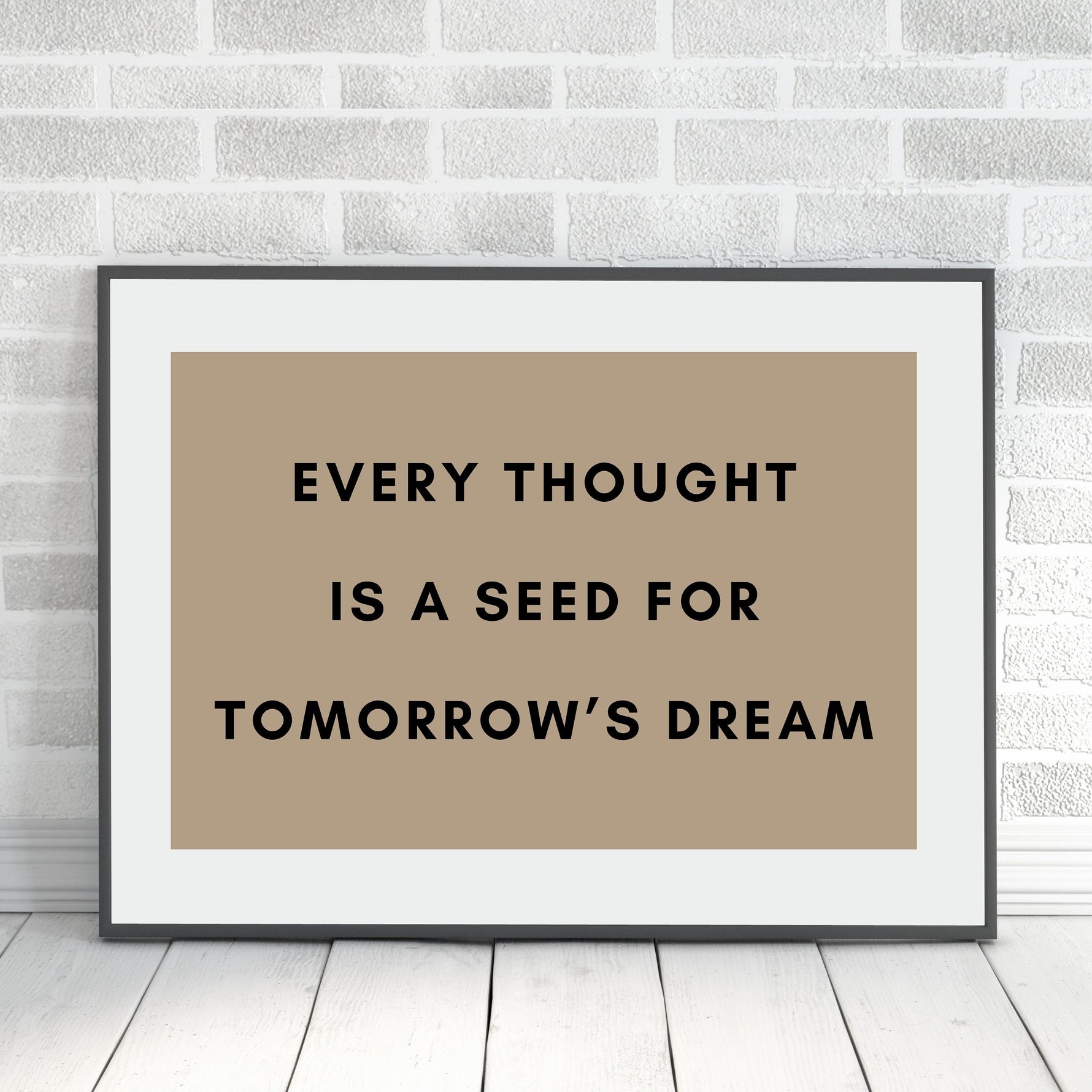 a picture of a brown and black quote on a white brick wall